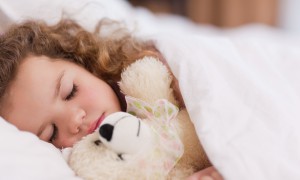 Girl sleeping with her teddy